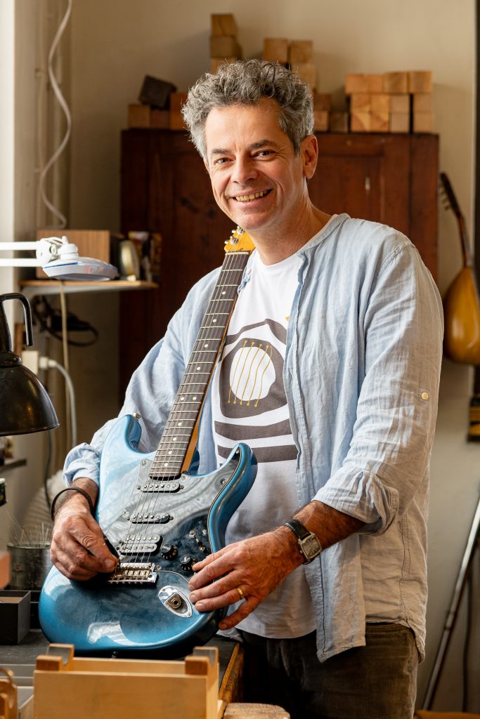 Gitarrenbauer in seiner Werkstatt, bei der Arbeit an einem Zupfinstrument